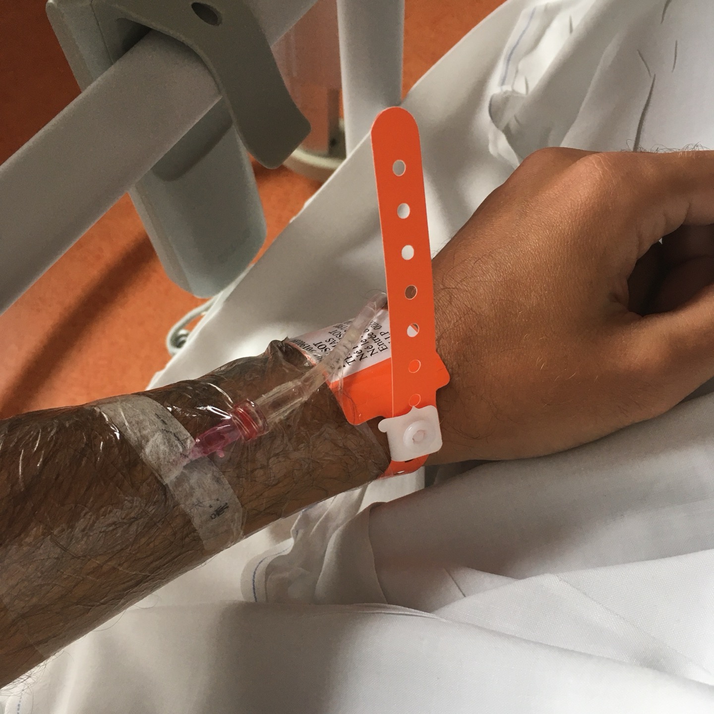 photo rapprochée d’un bras avec un cathéter suite à une opération en hôpital public